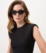 Vestido midi negro confeccionado en scuba crepé, sin mangas y con hombros estructurados. Presenta diseño ajustado en la parte superior y ruedo asimétrico con punta alargada lateral.