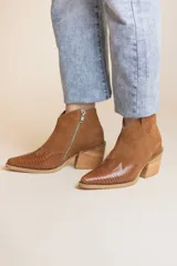 Botín de cuero color marrón con punta fina, detalle de textura simil reptil en la puntera y lateral externo, cierre lateral con cremallera y taco de madera.