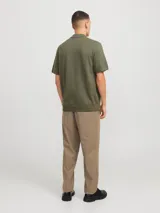 Polo de punto de manga corta en color verde oliva, con cuello clásico y cierre frontal parcial con cremallera. Presenta un tejido estructurado y corte regular.