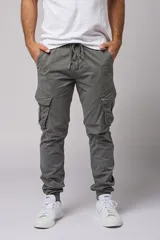 Pantalón cargo color beige de gabardina, con corte ajustado, bolsillos laterales con fuelle y puños elásticos en los tobillos.