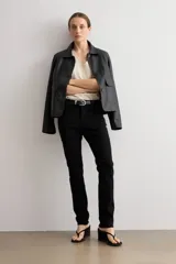 Pantalón slim de denim negro, con tiro medio, corte ajustado y bolsillos clásicos.