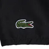 Short de baño Lacoste color negro, con cintura elástica y cordón de ajuste blanco. Presenta el logo de la marca bordado en la parte inferior derecha y detalles en color verde en el interior de la cintura y los bolsillos laterales.