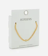 Collar corto de acero inoxidable con baño dorado, diseño de cadena plana tipo serpiente con detalles de estrellas grabadas a lo largo de la pieza. Fabricado con metal reciclado y resistente al agua.