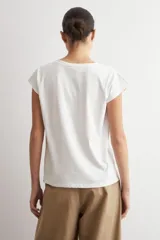 Remera blanca de manga corta, con cuello en V decorado con detalles de vainillas.