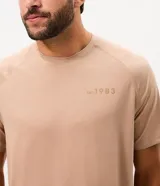 Remera deportiva de hombre con tecnología dry, confeccionada en tejido técnico con textura. Presenta cuello redondo, manga corta y estampa en gel en la espalda con la leyenda Court & Leisure Club 1983.