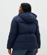 Campera puffer acolchada color azul marino, con capucha, cierre frontal con broches a presión, bolsillos laterales y cordón regulador en la cintura para ajuste entallado.