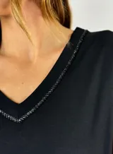 Remera blanca de corte holgado con cuello en V y ribete de crochet.