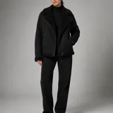 Campera gamulán negra con interior y detalles de corderito sintético, solapas grandes, bolsillos con cierre y cierre frontal cruzado.