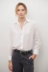 Camisa de mujer a rayas verticales blancas y rosadas, con cuello clásico, cierre de botones frontal y mangas largas con puños abotonados.