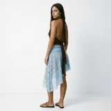Falda de encaje color celeste, con diseño de largo irregular y corte asimétrico.