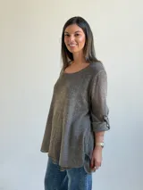 Sweater de punto color marrón chocolate, con escote redondo, mangas tres cuartos con trabilla y botón, y diseño holgado y acampanado.