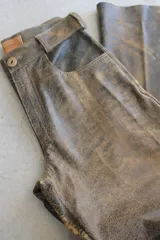 Pantalón de cuero napa color marrón con efecto envejecido, corte recto y trabillas para cinturón.