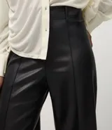 Pantalón wide leg de poliuretano color negro, con cintura de tiro alto, trabillas para cinturón, cierre frontal y bolsillos traseros aplicados.