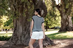 Blusa a rayas horizontales en tonos gris y blanco, con cuello y sisas en azul marino.