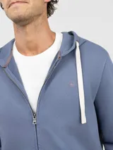 Sudadera con cierre frontal y capucha, confeccionada en felpa de algodón. Presenta un diseño liso con cordones ajustables en la capucha y bolsillos tipo canguro.