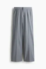 Pantalón sastrero gris de tiro alto, con pliegues marcados al frente y piernas anchas y rectas.