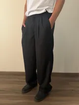 Pantalón sastrero de corte holgado con pinzas en el delantero y el trasero. Cuenta con cintura con elástico en la parte posterior y bolsillos laterales.