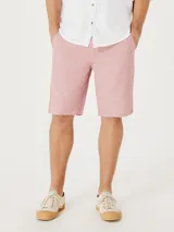 Bermuda de sarga modelo chino, color rosado, con cierre de botón y cremallera, bolsillos laterales y corte recto.