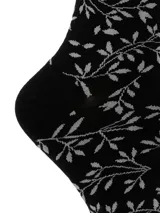 Medias de largo medio color negro con estampado de ramas y hojas en gris. Presentan un borde superior con terminación ondulada.