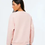 Buzo de cuello redondo y manga larga, confeccionado en tejido de punto fino con diseño liso y corte holgado.