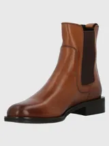 Bota estilo Chelsea de cuero color marrón, con paneles laterales elásticos en contraste y taco bajo cuadrado.