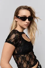 Top de encaje blanco con diseño ajustado al cuerpo, mangas cortas y detalle de cut-out en el escote.