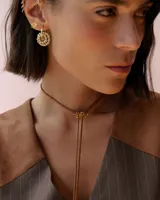 Gargantilla tipo choker de tiento de gamuza color marrón con dije central de acrílico transparente en forma de estrella.