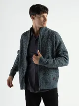 Campera de punto con cierre frontal, cuello alto y forro interno. Presenta un diseño de tejido jaspeado con puños y ruedo acanalados, e incluye un pequeño aplique de marca en la parte inferior.
