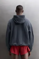 Sudadera de algodón con interior de rizo, corte relaxed fit, color gris oscuro. Cuenta con cuello con capucha y abertura frontal en V, manga larga y bajo con puños elásticos.