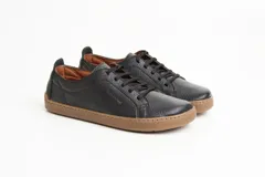 Zapatillas de cuero blanco con diseño minimalista, cordones al tono y suela de goma color suela con costura vista.