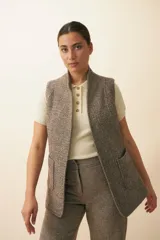 Chaleco marrón con diseño de espiga, corte entallado, solapa y bolsillos plaqué. Prenda al corte y terminaciones envivadas.