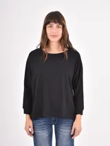 Remera de manga larga color negro, con cuello redondo y puños elásticos, de corte holgado.
