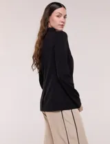 Blazer de silueta semientallada color negro, confeccionado en sastrería liviana con solapa muesca clásica, cierre frontal de un solo botón y bolsillos frontales.