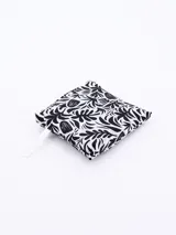 Bolsa de compras plegable con estampado botánico en blanco y negro, que incluye un gancho plástico para su transporte.