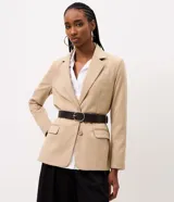Blazer sastre color beige, de corte estructurado y calce al cuerpo, con solapa clásica, bolsillos con solapa en los laterales, bolsillo superior y cierre frontal de un botón.
