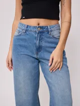 Jean de corte wide leg con tiro medio, confeccionado en denim de algodón en tono azul medio con efecto lavado.