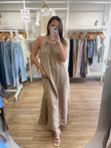 Vestido largo de lino color negro oscuro, con escote fruncido y tirantes finos ajustables. Presenta aberturas laterales en el ruedo.