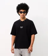 Remera boxy negra de algodón con cuello V decorado con pequeñas estrellas bordadas y un bordado numérico en el centro del pecho.