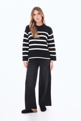 Jean de corte wide leg en color azul medio con efecto lavado. Presenta tiro medio, cierre frontal con botón y bolsillos laterales y traseros.