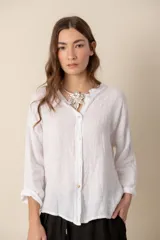 Camisa de lino color rosado, de corte holgado y cuello mao, con mangas 3/4 y cierre frontal con botones. 