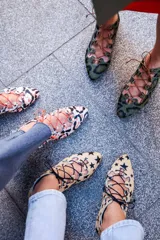 Semibotín de piel de pony con estampado animal print en tonos verde y marrón. Presenta un diseño con aberturas laterales onduladas, cierre de cordones finos y punta afilada. Cuenta con suela de cuero y cuña interna.