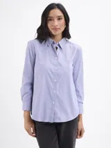 Camisa de corte clásico con estampado de rayas verticales finas en color azul y blanco, cuello camisero y cierre frontal con botones.