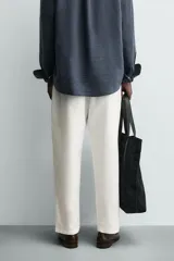 Pantalón de corte relajado confeccionado en una mezcla de algodón y lino. Presenta cintura elástica con cordón ajustable, bolsillos laterales y bolsillos traseros de vivo.