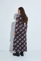 Falda larga de corte fluido con estampado de cuadros en tonos oscuros, rojizos y blancos. Presenta un diseño ligero con terminaciones onduladas en el ruedo.