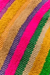 Bolso tipo tote bag confeccionado en yute 100%, con diseño de rayas verticales multicolor de textura esponjosa y asa de mano revestida en fibra natural. Cuenta con cierre de imán.