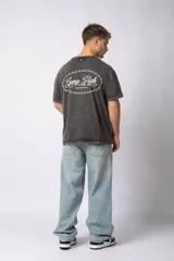 Remera de algodón con efecto lavado ácido en color gris, de corte holgado y manga corta. Presenta estampados gráficos minimalistas en el pecho y cuello redondo acanalado.