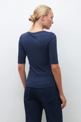Remera verde de tejido canalé con cuello redondo y media manga. Tiene una abertura frontal con botones.