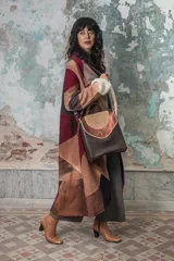 Cartera marrón de cuero con solapa color cobre y bordado artesanal.