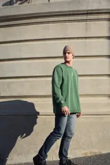 Buzo verde con cuello redondo y logo pequeño bordado en el pecho.