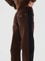 Jean barrel colorblock de denim azul marino y pana bordó, con pierna ancha que se estrecha hacia el tobillo. Presenta cintura ajustada y corte relajado en cadera y muslo.